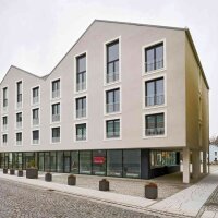 Der neugeschaffene Wohnkomplex besteht aus zwei Baukörpern mit Satteldach und einer gastronomisch genutzten Erdgeschosszone.