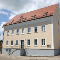 Die frisch sanierte Fassade wird von der Sonne angestrahlt. 
