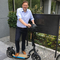 Verkehrsminister Dr. Hans Reichhart auf einem E-Scooter vor dem Ministerium